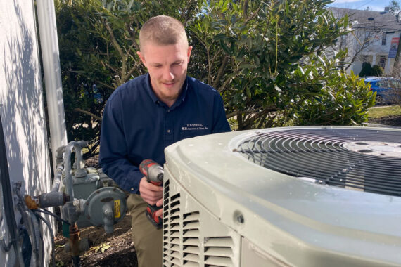 Diligent HVAC technician servicing an air conditioning unit in Lancaster County, essential for emergency HVAC solutions.