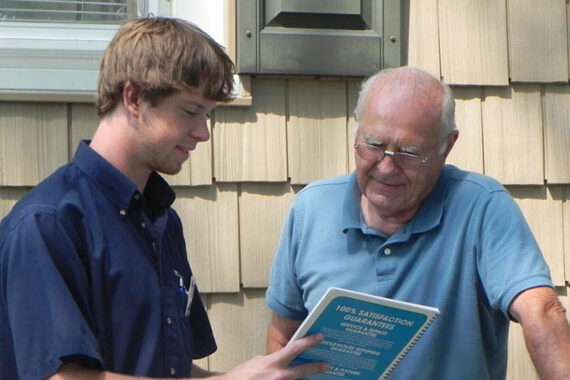 Customer satisfaction in Lancaster County: A friendly HVAC technician discusses emergency services with a homeowner.