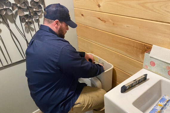 Professional plumbing technician in Lancaster County addressing an emergency toilet repair.