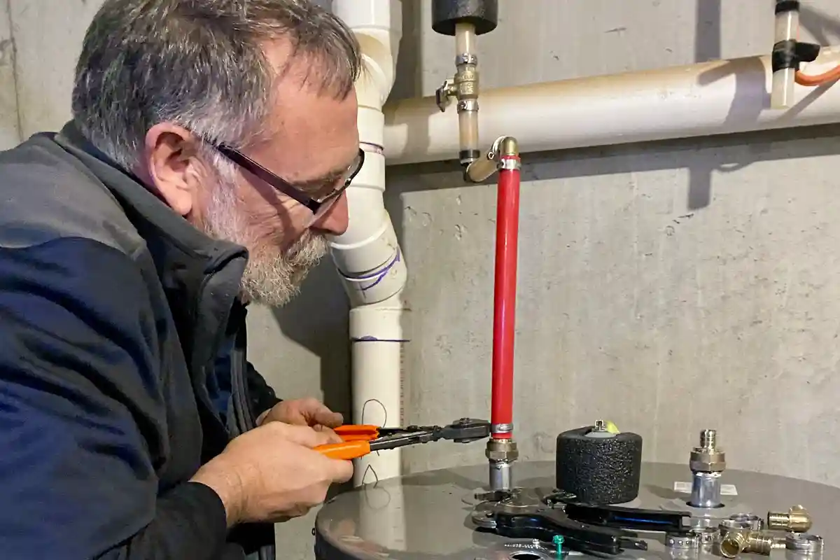 Experienced technician meticulously installing a new hot water heater in a Lancaster home, ensuring precise and reliable plumbing solutions.