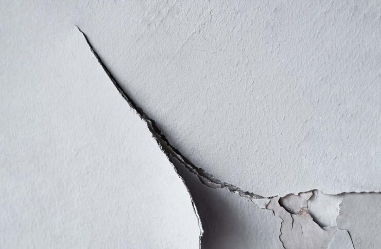Close-up of cracked paint on a wall, indicative of the damaging effects of low indoor humidity.